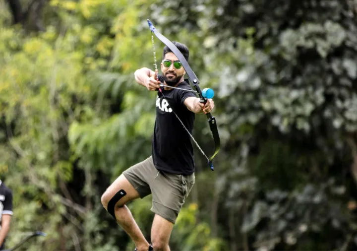 Player aiming a bow during archery tag