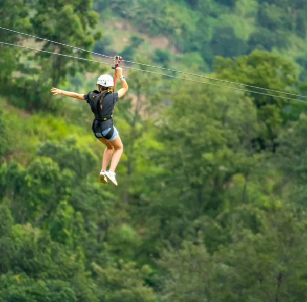 Guest riding the zipline through the forest