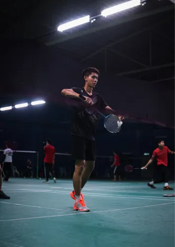 Indoor badminton court under lights at Sportico Resorts