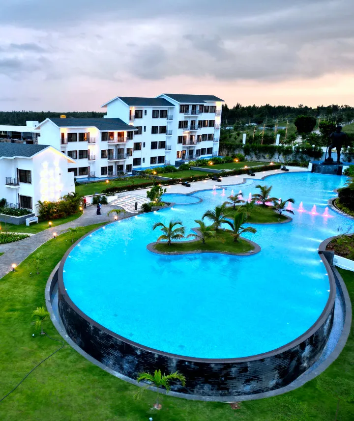 Aerial view of the island pool and villas at Sportico Resorts near Bangalore